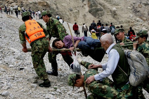 5月15日,解放軍官兵在都江堰紫坪鋪大壩將從汶川縣映秀鎮(zhèn)通過水路運(yùn)出的受傷災(zāi)民送往醫(yī)院救治。 新華社記者 查春明 攝