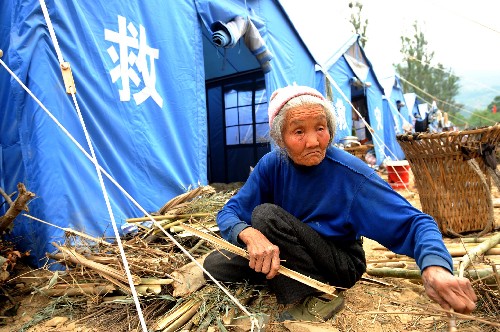 一位受災(zāi)老人在安置點(diǎn)里撿拾柴草(5月20日攝)。 四川省綿陽(yáng)市平武縣南壩鎮(zhèn)的模子樹村安置點(diǎn)現(xiàn)有受災(zāi)群眾4200多名,是該鎮(zhèn)規(guī)模最大的安置點(diǎn)。綿陽(yáng)到平武的道路搶通后,各類救援物資不斷運(yùn)送進(jìn)來(lái),受災(zāi)群眾的生活得到了基本保障。 新華社記者周文杰攝