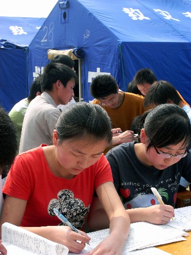 5月23日,寧強縣第一中學(xué)高三學(xué)生在臨時“教室”外復(fù)習(xí)。 四川汶川大地震發(fā)生后,與四川震區(qū)毗鄰的陜西省寧強縣26個鄉(xiāng)鎮(zhèn)全部受災(zāi),全縣233所中小學(xué)有226所受災(zāi)。陜西省有關(guān)部門正全力幫助當(dāng)?shù)厥転?zāi)學(xué)校搭建臨時校舍、加快校舍維修等,力爭讓學(xué)生們早日復(fù)課。 新華社發(fā)(鄭元平 攝)