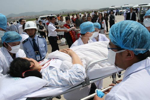 5月23日,在煙臺(tái)國(guó)際機(jī)場(chǎng),醫(yī)療救護(hù)人員將傷員抬下飛機(jī)。 新華社發(fā)(柴向陽(yáng) 攝)