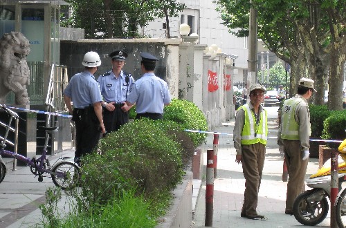 7月1日,警察和交通協(xié)管員正在案發(fā)現(xiàn)場(chǎng)外維持秩序?! ‘?dāng)日9時(shí)40分許,一名外地來(lái)滬男子持刀闖入上海市公安局閘北分局,用刀連續(xù)捅向多名民警和保安,5名民警送醫(yī)院搶救無(wú)效犧牲,另有4名民警和1名保安受傷。 新華社記者 裴鑫攝
