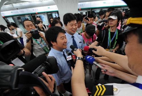7月19日,記者采訪地鐵奧運(yùn)支線首趟列車駕駛員劉磊(左)、孫崇緯。當(dāng)日上午,在京媒體記者搶先體驗(yàn)即將于下午正式開通的北京地鐵奧運(yùn)支線。北京地鐵奧運(yùn)支線位于北京市南北中軸線下,奧林匹克中心區(qū)內(nèi),全線共設(shè)4座車站,是惟一直接進(jìn)入奧運(yùn)中心區(qū)的地鐵線路。 新華社記者 李文攝