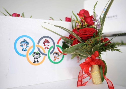 7月25日,名為“紅紅火火”的北京奧運會和殘奧會的頒獎花束在北京奧運花卉配送中心首次向中外媒體亮相。頒獎花束整體呈尖塔狀,高40厘米,胸徑25厘米,由主花材月季和火龍珠、假龍頭、書帶草、玉簪葉和芒葉等配花配葉組成?;ㄊ暮Y(jié)以中國絲綢為材,采用傳統(tǒng)中國結(jié)的樣式制作而成,絲帶上印有北京奧運會會徽。 北京奧運會和殘奧會期間,將有6000束頒獎花束展現(xiàn)在奧運會和殘奧會的頒獎臺上。 新華社記者羅曉光攝