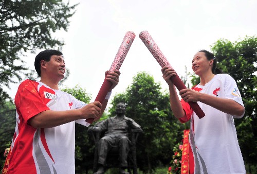 8月3日,火炬手陳靜(右)與李良國在鄧小平銅像前進行圣火交接。當(dāng)日,北京奧運圣火在四川省廣安市傳遞。 新華社記者劉力航攝