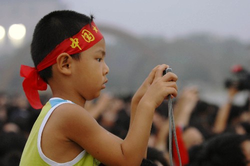 8月8日,一名小朋友在北京天安門廣場(chǎng)拍攝升旗儀式。當(dāng)日20時(shí),北京奧運(yùn)會(huì)開(kāi)幕。 新華社記者 金良快 攝