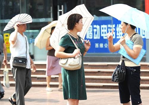 9月24日,室外活動的市民選擇了各自的遮陽工具。 新華社記者 周衡義 攝