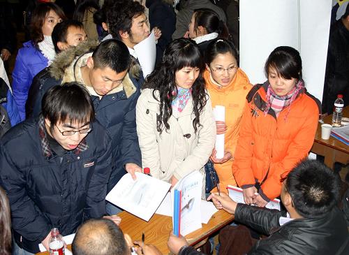 12月7日,前來應(yīng)聘的大學(xué)生在就業(yè)洽談會現(xiàn)場向招聘單位工作人員咨詢。 新華社記者 李澤兵 攝