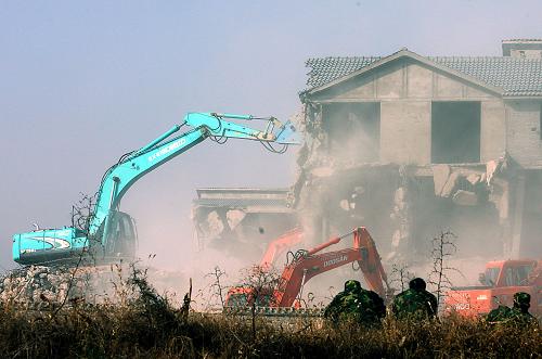 12月17日,兩臺鏟車在拆除建在洛陽龍門西山的別墅群。 新華社記者 王頌 攝