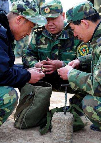 3月10日,包鋼199拋射炮分隊的戰(zhàn)士們準備炸藥破冰。 新華社記者 任軍川 攝