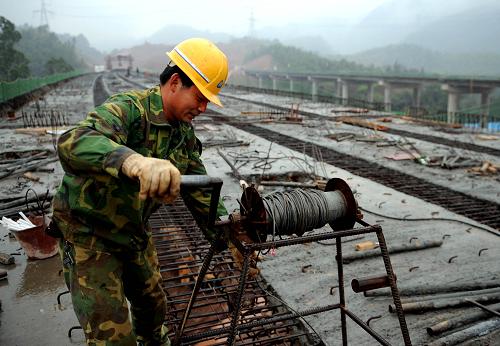 3月10日,施工人員在鋪設(shè)鐘山至馬江段高速公路大桂山大橋路面。 新華社記者 張愛林 攝