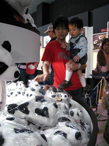 4月12日,一對(duì)母子在臺(tái)北木柵動(dòng)物園熊貓館紀(jì)念品商店里選購(gòu)熊貓玩具。 新華社記者 余福卿 攝
