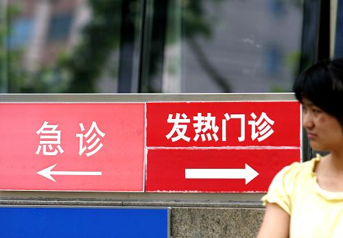 行人從上海一家醫(yī)院的發(fā)熱門診標(biāo)示牌前走過(攝于5月28日)。 新華社記者 劉穎 攝