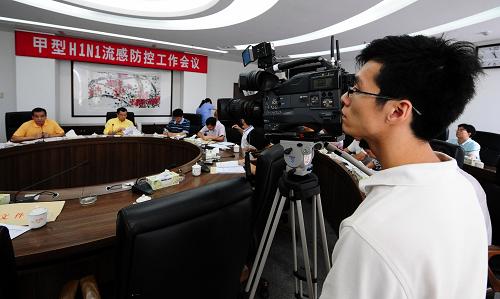 6月20日,一位當(dāng)?shù)赜浾咴谑沛?zhèn)政府召開的甲型H1N1流感防控工作會議上拍攝。 新華社記者 陳曄華 攝