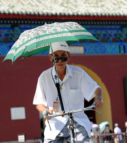 6月24日,一位老人在自行車上安裝了一把遮陽傘在北京街頭騎行。當日,北京的最高氣溫升至37℃以上,北京市氣象臺將高溫預(yù)警信號由黃色升級為更高級別的橙色。氣象專家提醒市民,要盡量避免在強烈陽光下進行戶外活動,特別是午后高溫時段要避免長時間在陽光下暴曬,同時采取防曬和降暑措施。 新華社記者 李文 攝