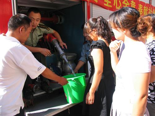 8月3日,消防戰(zhàn)士在赤峰市新城區(qū)長(zhǎng)安小區(qū)為群眾供水。 新華社記者 王宇天 攝