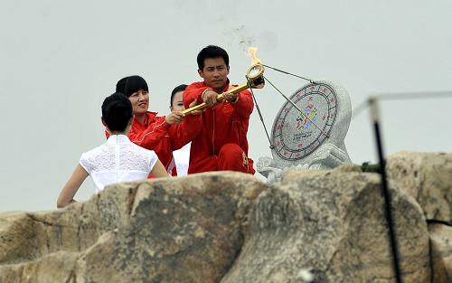 8月1日,奧運(yùn)冠軍王峰(右)和張娟娟采集圣火火種。當(dāng)日,第十一屆全國運(yùn)動(dòng)會(huì)圣火火種在泰山之巔采集。 新華社記者 范長國 攝
