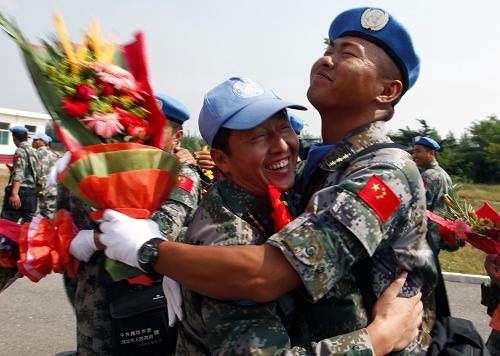 9月18日,先期回國的第一梯隊戰(zhàn)士(左)和凱旋的戰(zhàn)友擁抱。 新華社發(fā)(畢華明 攝)
