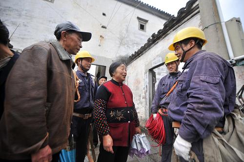 2月9日,電力服務(wù)人員提醒朱旺村居民注意用電安全。 新華社記者 王雷 攝