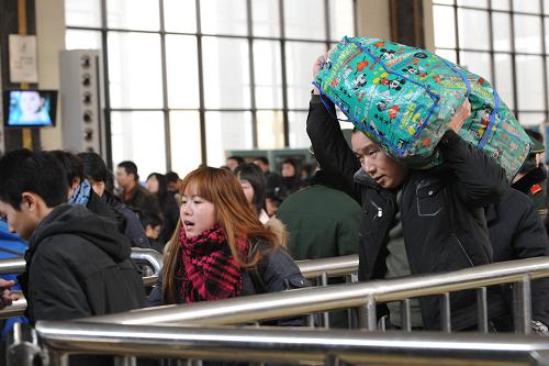 2月11日,乘客在鄭州火車站進站上車。當日,作為全國交通樞紐的鄭州火車站客流大幅上升,預(yù)計當日發(fā)送旅客達10萬人次左右,達到春運以來的最高峰。新華社記者 趙鵬 攝