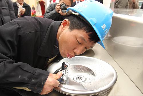 3月30日,一名工人率先體驗(yàn)世博直飲水。新華社記者 任瓏 攝