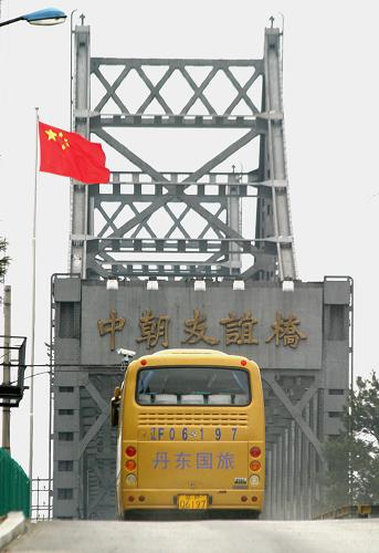 4月12日,在遼寧丹東口岸,赴朝首發(fā)團(tuán)游客向送別的人們揮手告別。 新華社發(fā)(戚萬鵬 攝)