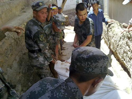 8月8日,蘭州軍區(qū)某集團軍防化團官兵正在抬出搜尋到的遇難者遺體。新華社稿 (王彥軍 攝)