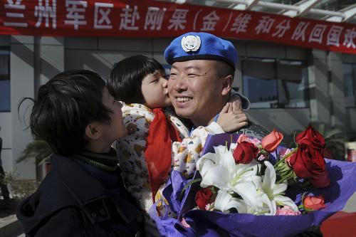 11月21日,在西安咸陽國際機場,6歲小姑娘王遠笛(中)在媽媽陪同下,迎接剛剛執(zhí)行完維和任務的爸爸回國。新華社發(fā)(武國強 攝)