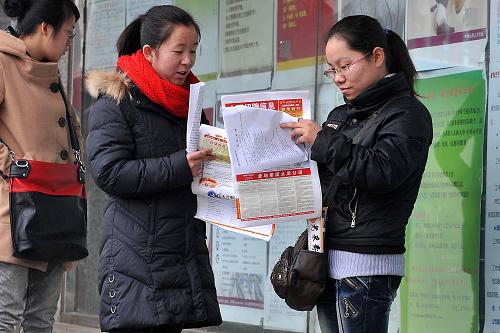 2月10日,兩名求職者在閱讀用人單位的招聘信息。新華社記者 詹彥 攝