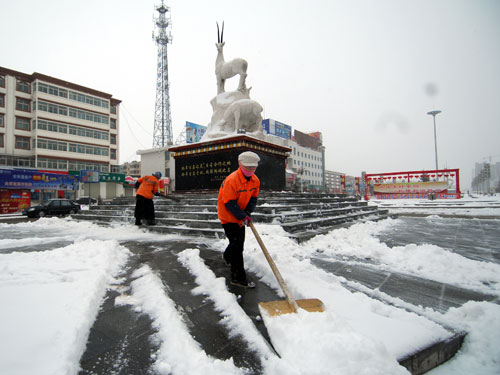 2月17日,兩名清潔工正在清理市區(qū)內(nèi)的積雪。新華社記者 高健鈞 攝