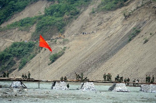 5月20日,空軍某部的舟橋部隊(duì)在架設(shè)通往平武縣南壩鎮(zhèn)的便橋。汶川大地震發(fā)生后,通往綿陽(yáng)市平武縣的道路被毀壞。到目前為止,南壩鎮(zhèn)以北的平武縣周邊山區(qū)還不能通車,加大了救援的難度,有關(guān)單位正在加緊搶修。 新華社記者 周文杰 攝