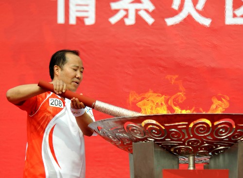 6月14日,火炬手袁仁國(guó)點(diǎn)燃圣火盆。當(dāng)日,北京奧運(yùn)火炬?zhèn)鬟f活動(dòng)在貴州省遵義市舉行。 新華社記者侯少華攝