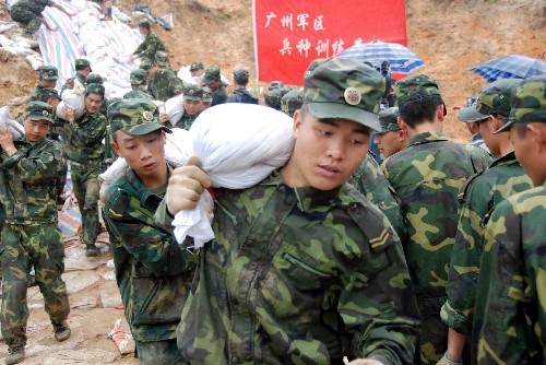 6月18日,廣州軍區(qū)某部戰(zhàn)士背運沙袋。 6月15日,持續(xù)強降雨造成京廣鐵路廣東清遠(yuǎn)龍?zhí)炼窝鼐€6處山體滑坡,部分路段嚴(yán)重淤積和內(nèi)澇。為防止山體滑坡影響京廣交通大動脈,上千名駐軍、武警官兵和群眾趕赴現(xiàn)場,對險患地段進(jìn)行搶險加固,確保鐵路運營安全。 新華社發(fā)(李作描 攝)