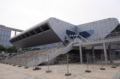 外形似飛碟從天而降的北京航空航天大學(xué)體育館改建工程于2007年12月17日竣工交付使用,2008年這里將舉辦奧運會和殘奧會舉重比賽。北航體育館建成于2001年8月,總建筑面積超過2萬平方米。改建工程于2007年1月底正式開工。整個工程充分顯示“節(jié)儉辦奧運”的理念。場館在改建過程中所采用的原材料、設(shè)備均通過環(huán)保、節(jié)能部門的檢測和認(rèn)證。場地內(nèi)搭建的臨時看臺,均采用模塊化腳手架支撐系統(tǒng)搭建,便于賽后場地的恢復(fù)及看臺設(shè)施的回收再利用。這是北航體育館外景(5月19日攝)。 新華社記者杜華舉攝