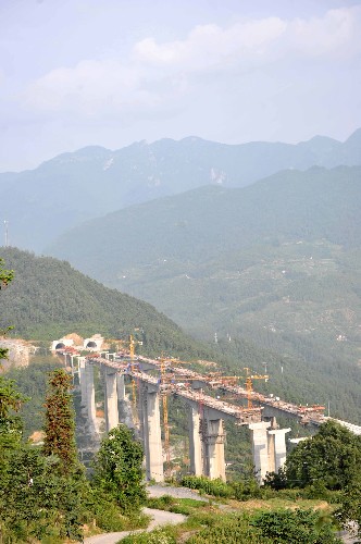 這是湖北省長陽土家族自治縣境內(nèi)正在建設(shè)中的滬蓉西高速公路關(guān)口埡大橋(7月7日攝)。湖北滬蓉西高速公路是迄今為止湖北省投資最大、工程最為艱巨、地質(zhì)最為復(fù)雜、建設(shè)周期最長的高速公路工程,也是目前全國建設(shè)難度最大的高速公路項目之一。滬蓉西高速公路東起湖北宜昌長江公路大橋,途經(jīng)宜都、長陽、巴東、建始、恩施、利川6個縣市,西止湖北省利川市魚泉口,全長約320公里,2004年開工,預(yù)計將于2009年全線竣工。 新華社記者 郝同前 攝