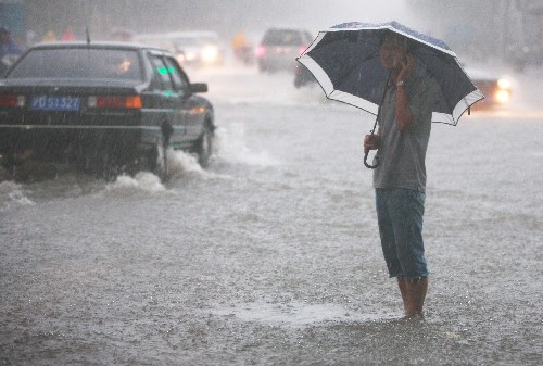 8月25日,一名行人在雨中打電話。當日清晨,上海突遭強雷暴雨襲擊,局部地區(qū)雨量已達大暴雨程度,1個半小時內(nèi)雨量超過了100毫米。 新華社記者 裴鑫攝