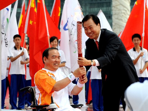 9月3日,大連市市長(zhǎng)夏德仁(右)將火炬交給第一棒火炬手李揚(yáng)。當(dāng)日,北京殘奧會(huì)圣火在大連進(jìn)行傳遞。 新華社記者 李鋼 攝