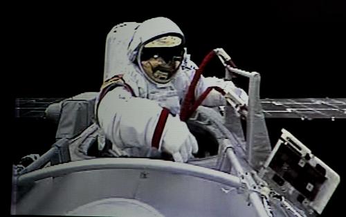 9月27日,執(zhí)行神舟七號載人航天飛行出艙活動任務的航天員翟志剛正在出艙(攝于北京航天飛行控制中心大屏幕)。新華社記者查春明攝