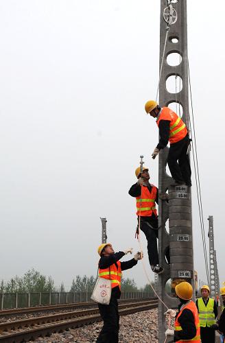 4月14日,中鐵電氣化局集團(tuán)一公司的施工人員在進(jìn)行起錨操作。當(dāng)日,中鐵電氣化局集團(tuán)一公司的施工人員在河北省境內(nèi)深州至邢家村區(qū)段成功架設(shè)起京九鐵路電氣化改造工程的第一條接觸網(wǎng)導(dǎo)線,標(biāo)志著京九鐵路電氣化改造工程進(jìn)入掛網(wǎng)架線階段。這項(xiàng)工程于2008年8月6日開工建設(shè),計(jì)劃2009年底竣工。京九鐵路實(shí)現(xiàn)電氣化改造后,列車運(yùn)行最高時(shí)速將從160公里提高到200公里,運(yùn)輸能力將提高近30%。新華社記者 王民 攝