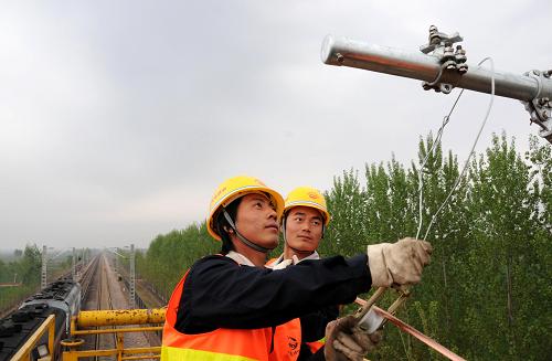 4月14日,中鐵電氣化局集團(tuán)一公司的施工人員正在掛線。當(dāng)日,中鐵電氣化局集團(tuán)一公司的施工人員在河北省境內(nèi)深州至邢家村區(qū)段成功架設(shè)起京九鐵路電氣化改造工程的第一條接觸網(wǎng)導(dǎo)線,標(biāo)志著京九鐵路電氣化改造工程進(jìn)入掛網(wǎng)架線階段。這項(xiàng)工程于2008年8月6日開工建設(shè),計(jì)劃2009年底竣工。京九鐵路實(shí)現(xiàn)電氣化改造后,列車運(yùn)行最高時(shí)速將從160公里提高到200公里,運(yùn)輸能力將提高近30%。新華社記者 王民 攝