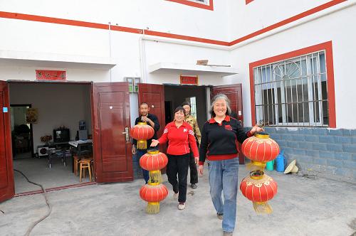 4月21日,方碑村村民準(zhǔn)備為新房掛紅燈籠。汶川地震使四川省綿陽(yáng)市安縣方碑村的房屋垮塌95%以上,基礎(chǔ)設(shè)施損毀嚴(yán)重。災(zāi)后方碑村在援建單位的幫助下,堅(jiān)持以人為本、科學(xué)規(guī)劃,一座座新房建起、一條條村路建成,目前已修建房屋390余戶,修建進(jìn)度完成95%。新華社記者 何俊昌 攝