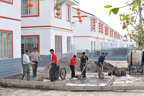 4月21日,方碑村村民為一戶新房建屋前小院。汶川地震使四川省綿陽(yáng)市安縣方碑村的房屋垮塌95%以上,基礎(chǔ)設(shè)施損毀嚴(yán)重。災(zāi)后方碑村在援建單位的幫助下,堅(jiān)持以人為本、科學(xué)規(guī)劃,一座座新房建起、一條條村路建成,目前已修建房屋390余戶,修建進(jìn)度完成95%。新華社記者 何俊昌 攝