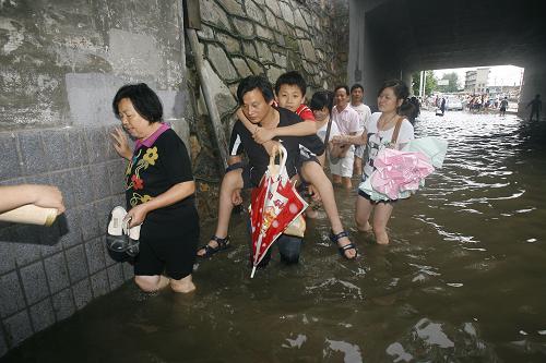 6月30日,武漢市區(qū)道路積水嚴重,市民艱難涉水。近日來,武漢連降暴雨,造成市區(qū)嚴重積水,給城市交通和市民生活造成較大影響。新華社發(fā)