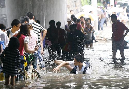 6月30日,武漢市區(qū)道路積水嚴重,市民艱難涉水。近日來,武漢連降暴雨,造成市區(qū)嚴重積水,給城市交通和市民生活造成較大影響。新華社發(fā)