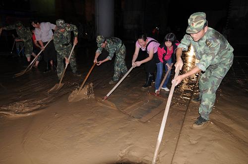 7月6日零時許,駐地部隊官兵和市民在柳州市濱江西路清理淤泥。7月5日晚至6日晨,廣西柳州市的洪水退去,當(dāng)?shù)亟M織人員對洪水退出地段進行清理。5日,柳江柳州水文站出現(xiàn)89.64米的洪峰水位,洪水量級相當(dāng)于20年一遇。新華社發(fā)
