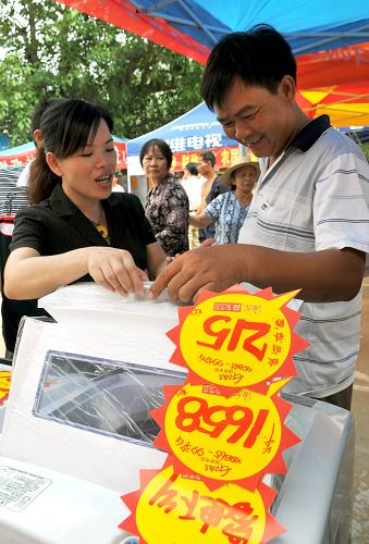 7月29日,??谑虚L(zhǎng)流鎮(zhèn)農(nóng)民在挑選洗衣機(jī)。近日,海南省開(kāi)展家電下鄉(xiāng)巡回展銷活動(dòng),26家中標(biāo)流通企業(yè)在全省18個(gè)市縣城鎮(zhèn)以及主要鄉(xiāng)鎮(zhèn)開(kāi)展巡回展銷,其中包括彩電、冰箱、手機(jī)、洗衣機(jī)等產(chǎn)品,凡在展銷現(xiàn)場(chǎng)購(gòu)買(mǎi)家電下鄉(xiāng)產(chǎn)品的農(nóng)戶都可以當(dāng)場(chǎng)兌付13%的財(cái)政補(bǔ)貼。海南省家電下鄉(xiāng)工作于2009年2月啟動(dòng),全省共建立1700余個(gè)銷售網(wǎng)點(diǎn),月均銷售產(chǎn)品1.58萬(wàn)件。新華社記者 郭程 攝