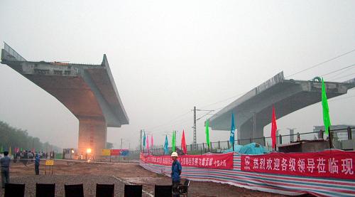 即將進(jìn)行同步轉(zhuǎn)體的雙幅立交橋(8月6日攝)。當(dāng)日6時(shí)30分左右,由中鐵六局石家莊鐵建公司承建的青(島)蘭(州)高速公路跨京廣鐵路和107國(guó)道分離式雙幅立交橋,在河北省邯鄲市磁縣成功實(shí)現(xiàn)同步轉(zhuǎn)體。拫據(jù)計(jì)劃,轉(zhuǎn)體施工期間該區(qū)段京廣鐵路中斷運(yùn)行40分鐘,107國(guó)道實(shí)施交通管制。據(jù)介紹,為了既能快速安全的架設(shè),又不影響鐵路和國(guó)道的運(yùn)行,大橋采用了雙幅平面轉(zhuǎn)體法施工,先在鐵路兩側(cè)分別建設(shè)主梁,然后水平轉(zhuǎn)體71.8度到設(shè)計(jì)橋位。新華社發(fā)(王九忠 攝)