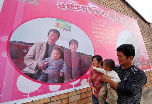 2009年以來,寧夏回族自治區(qū)鹽池縣開展計劃生育“明星之家”評選活動,為計劃生育模范家庭拍攝制作全家福照片。這是寧夏回族自治區(qū)鹽池縣宋新莊農(nóng)民宋強(qiáng)(右)一家在觀看自己的“明星之家”全家福照片(2009年8月24日攝)。新華社記者 王鵬 攝