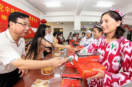 9月29日,天津市紅十字會和愛心企業(yè)代表向崇化中學新疆班的學生贈送節(jié)日食品和學習生活用品。當日,天津崇化中學500余名新疆班的學生在學校禮堂參加“紅十字博愛傳情 民族團結同樂慶佳節(jié)”主題聯(lián)歡活動。天津市紅十字會及愛心企業(yè)代表向學生們贈送了清真月餅等節(jié)日食品和學習生活用品。學生們共同聯(lián)歡,迎接新中國成立60周年和中秋佳節(jié)的到來。新華社發(fā)(李想 攝)