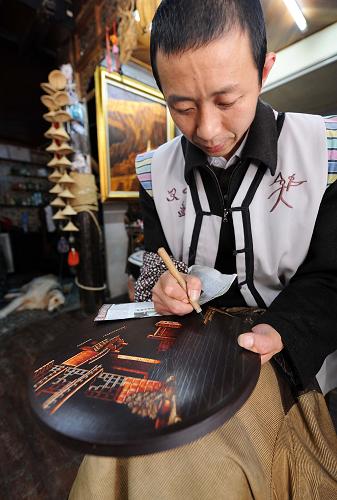 一位手工藝人在云南麗江古城的店鋪內(nèi)制作東巴盤,準備供應旅游市場(9月29日攝)。國慶長假將至,氣候宜人、風光旖旎的云南麗江成為國內(nèi)外游客理想的旅游目的地。加之大理至麗江鐵路已于9月28日正式通車,麗江旅游不斷升溫。新華社記者 藺以光 攝