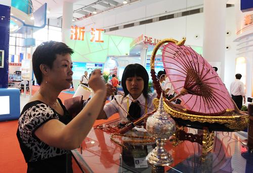 10月20日,參觀者選購(gòu)緬甸工藝品。當(dāng)日,中國(guó)—東盟博覽會(huì)在廣西南寧市國(guó)際會(huì)展中心開幕,東盟國(guó)家參展的首飾、玩具、鐘表等小商品引得觀眾駐足。 新華社記者 張愛(ài)林 攝